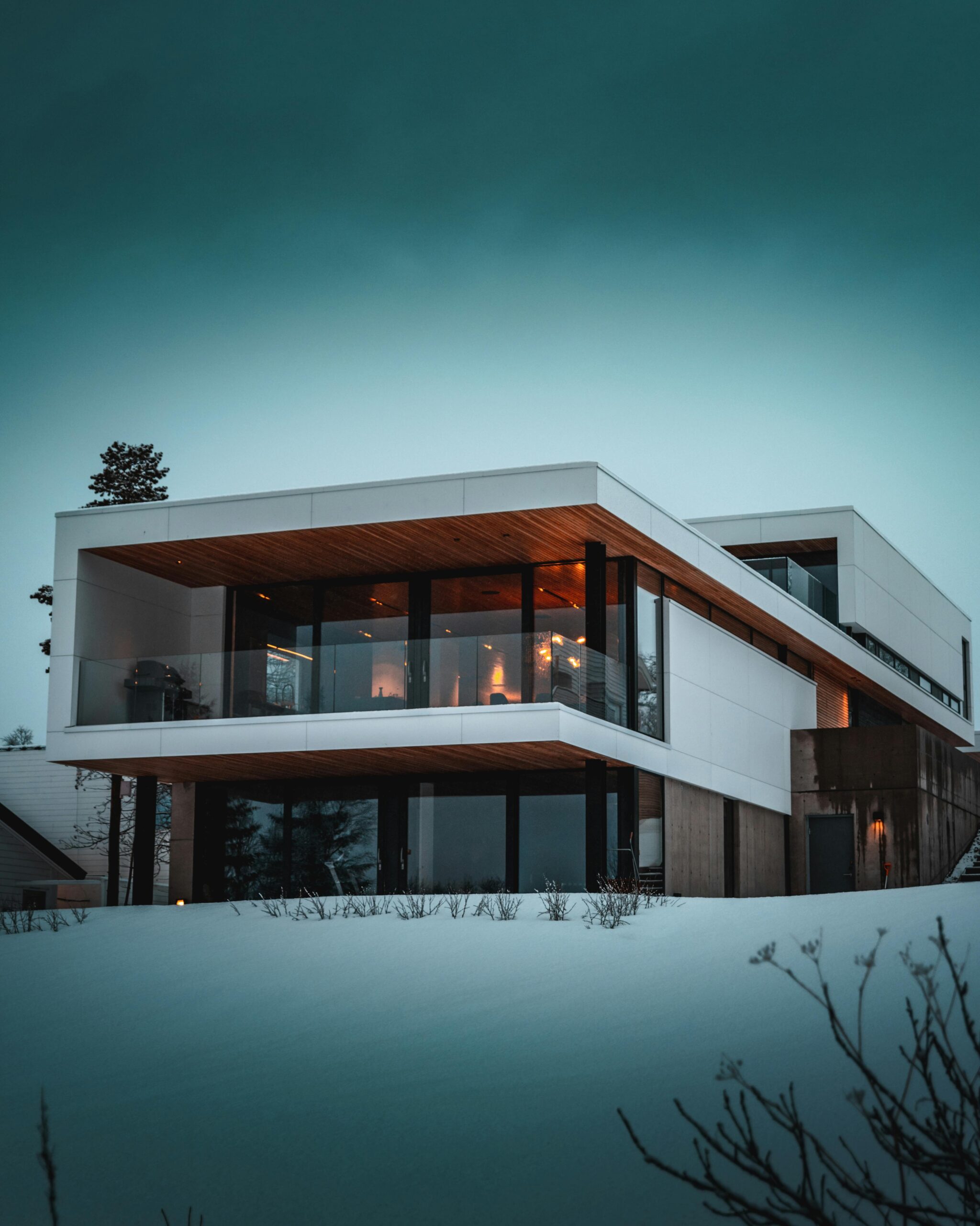 Stunning modern home with glass facade in snowy Troms, Norway, during winter.